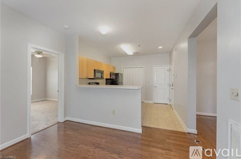 A spacious room with wooden flooring and white walls.