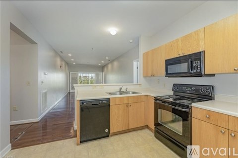 A kitchen with wooden cabinets and black appliances.