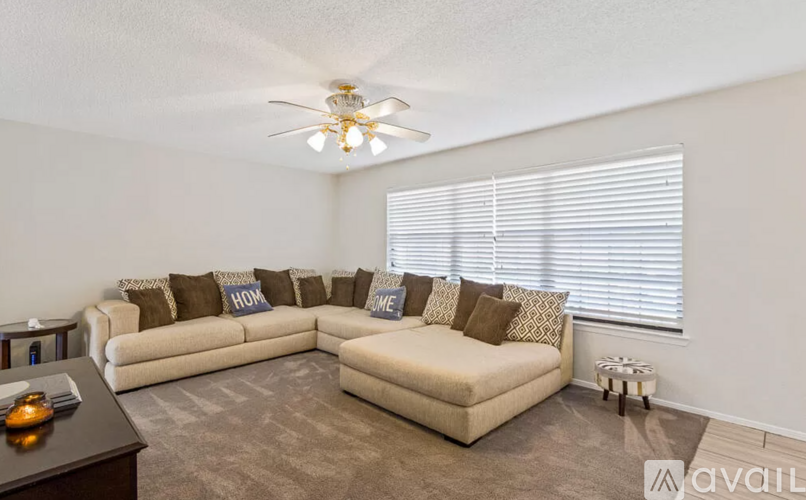 A living room with a beige sofa and a brown couch.