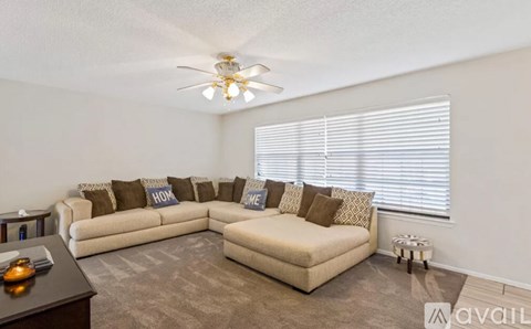 A living room with a beige sofa and a brown couch.