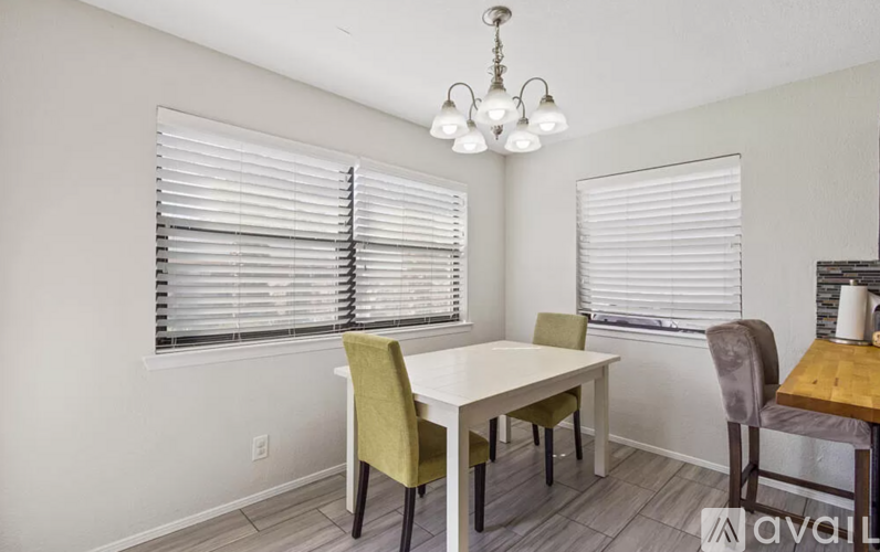 A dining room with a white table and chairs.