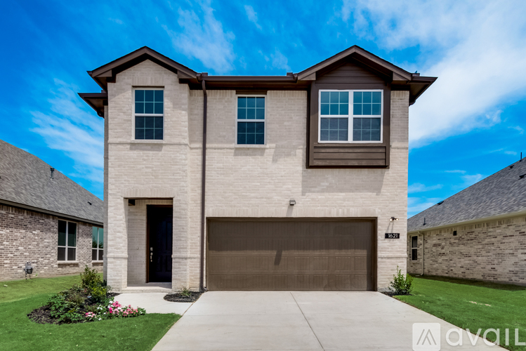A modern house with a garage door and a driveway.