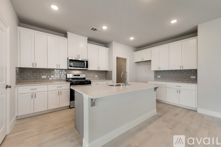 A modern kitchen with white cabinets and a central island.