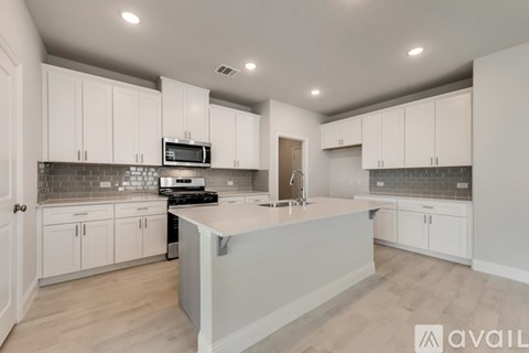 A modern kitchen with white cabinets and a central island.
