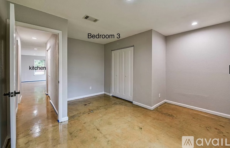 Bedroom 3 is empty and leads to the kitchen.