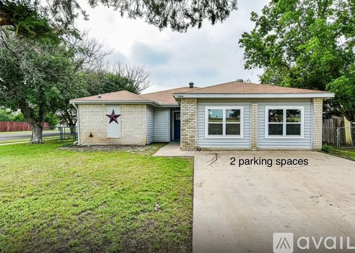 A house with a star on the door and two parking spaces in front.