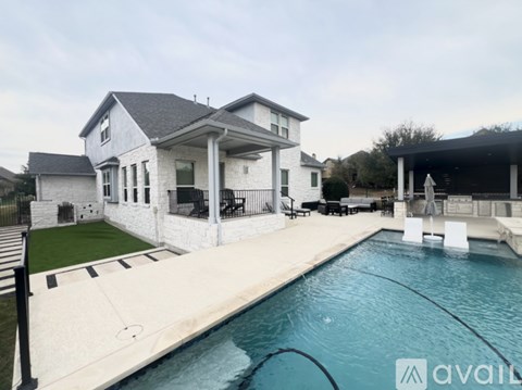 A house with a pool in front of it.