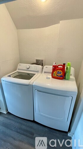 A small white washing machine and dryer in a laundry room.