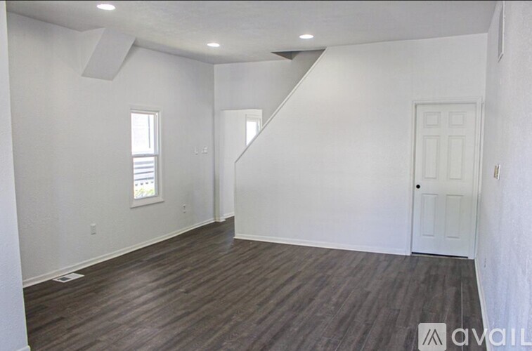 A room with a white door and a window with white blinds.
