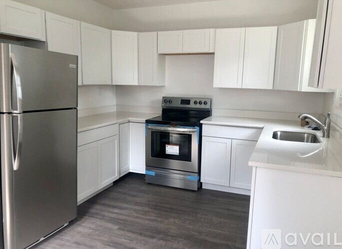 A modern kitchen with a stainless steel refrigerator, a stove, and a microwave.