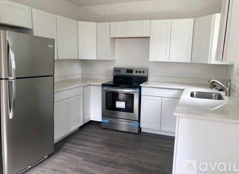 A modern kitchen with a stainless steel refrigerator, a stove, and a microwave.