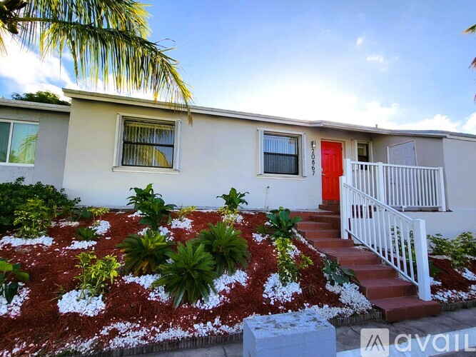 A house with a red door and a white fence.