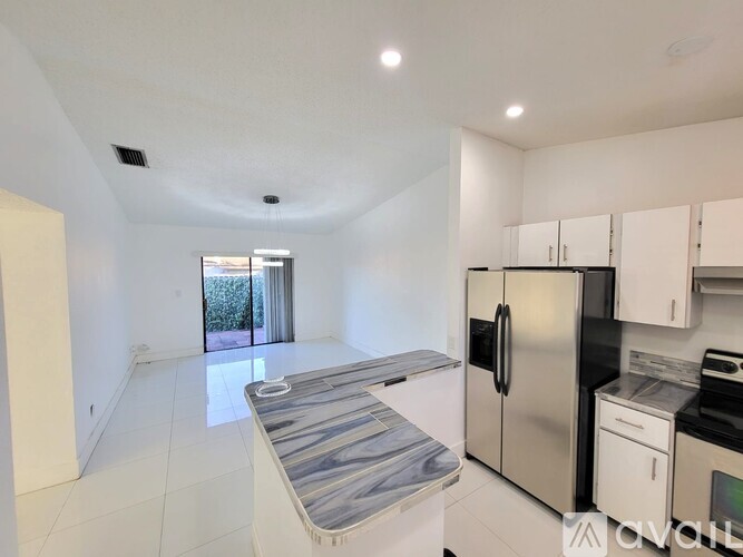 A kitchen with white cabinets and a stainless steel refrigerator.