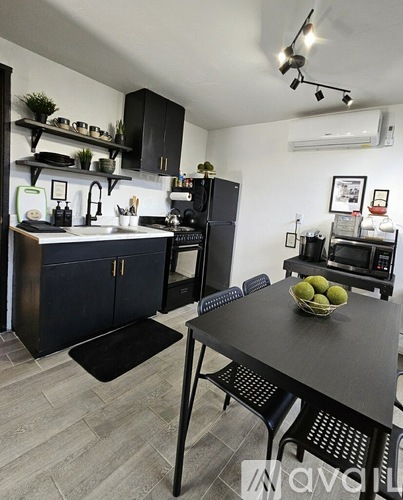 A kitchen with a table and chairs in the foreground and a refrigerator in the background.