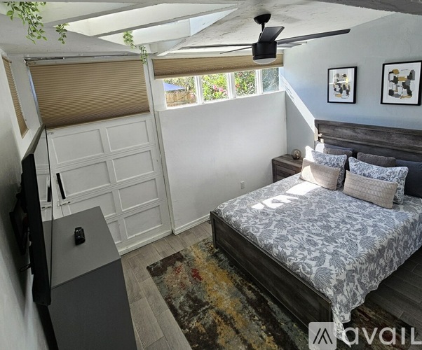 A bedroom with a bed, a ceiling fan, and a rug.