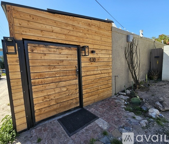 A wooden building with a black door and a number 430 on it.
