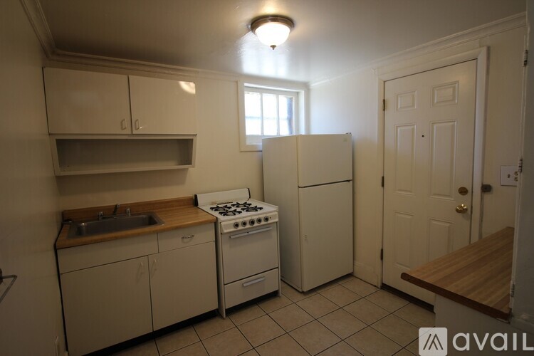 A kitchen with white appliances and cabinets.