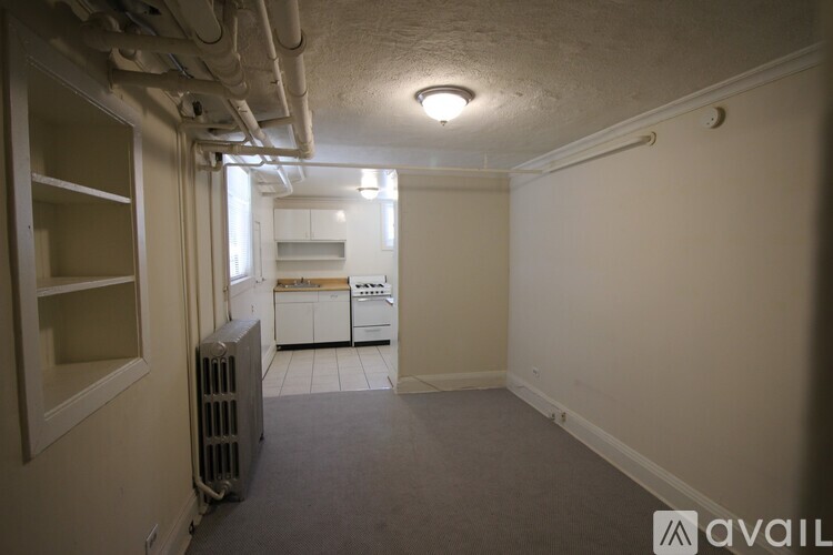 A small, empty room with a radiator and a window.