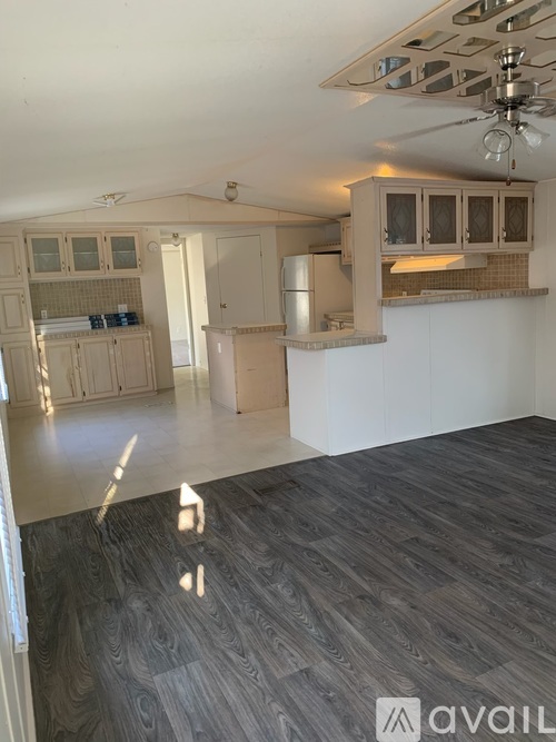 A kitchen with wooden floors and white walls.