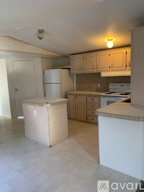 A kitchen with white appliances and cabinets.