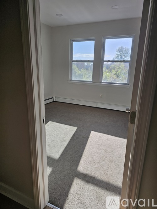 A room with a carpeted floor and a large window.