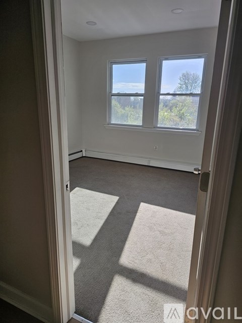 A room with a carpeted floor and a large window.