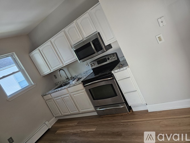 A kitchen with white cabinets and stainless steel appliances.