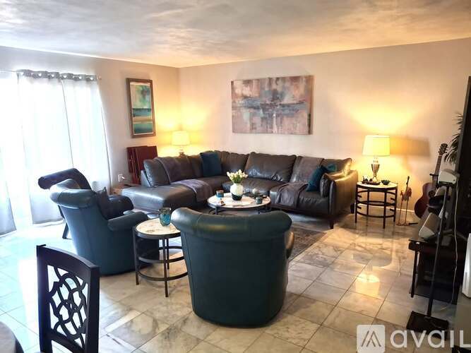 A living room with a couch, chairs, and a table.