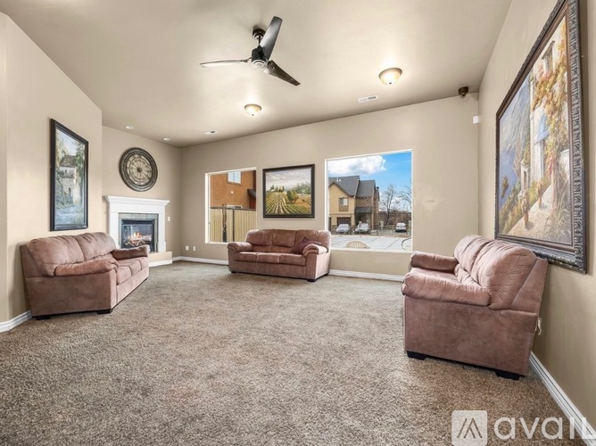 A living room with a fireplace, two chairs, and a sofa.