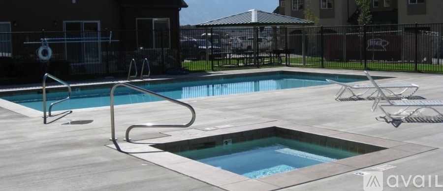A pool with a slide and a hot tub in front of a house.