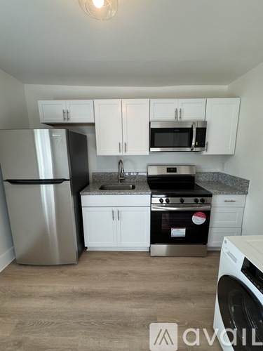 A kitchen with white cabinets and a black stove top oven.