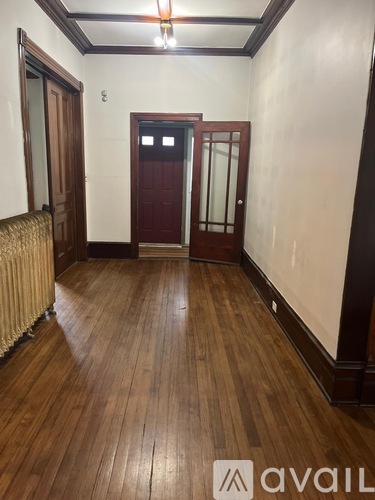 A room with wooden floors and a red door.