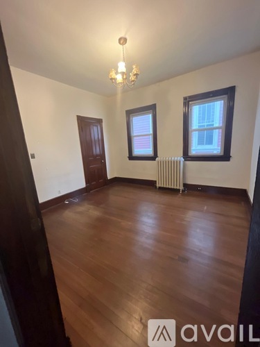 A room with wooden floors and a chandelier.
