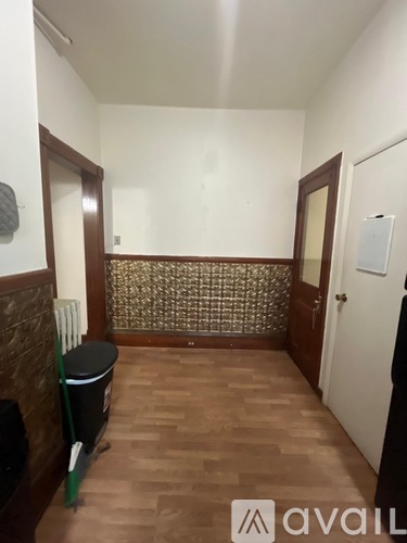 A hallway with a tiled floor and a wallpapered wall.