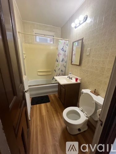 A bathroom with a toilet, sink, and shower.