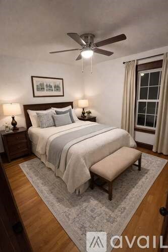 A bedroom with a large bed and a ceiling fan.