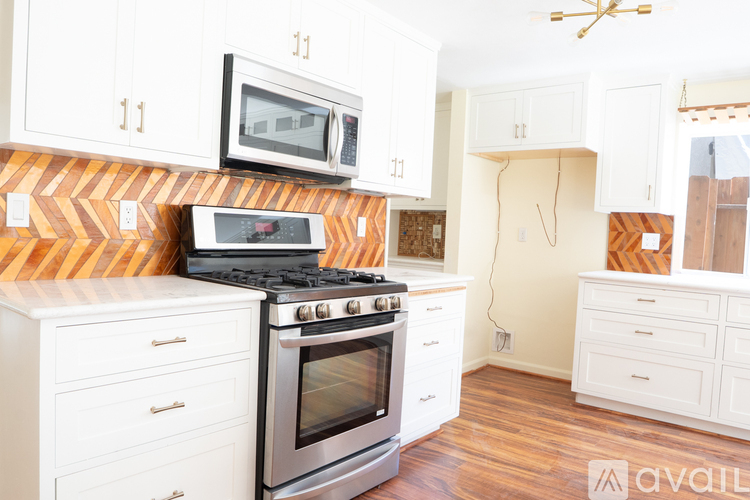 A kitchen with a stove top oven and a microwave above it.