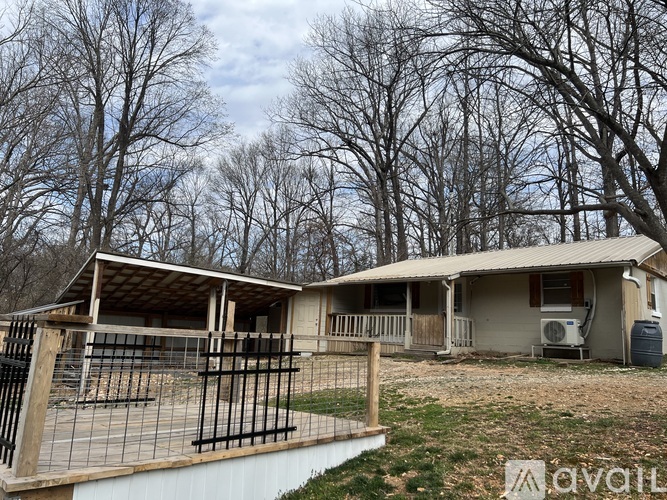 A house under construction with a partially completed roof and a fenced-off area in the foreground.