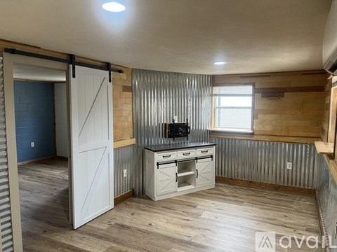 A kitchen with a wooden floor and a white door.