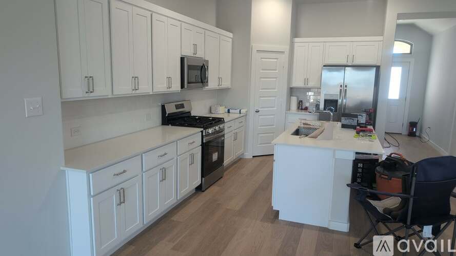 A kitchen with white cabinets and a wooden floor.