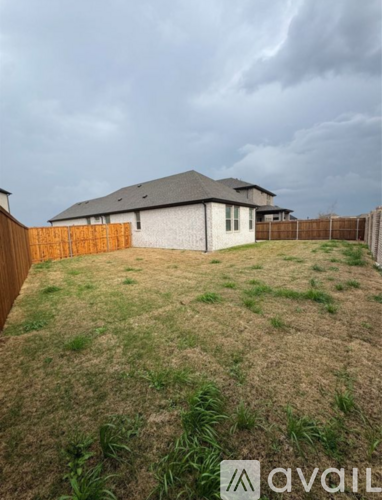 A house with a brown fence and a grassy yard.