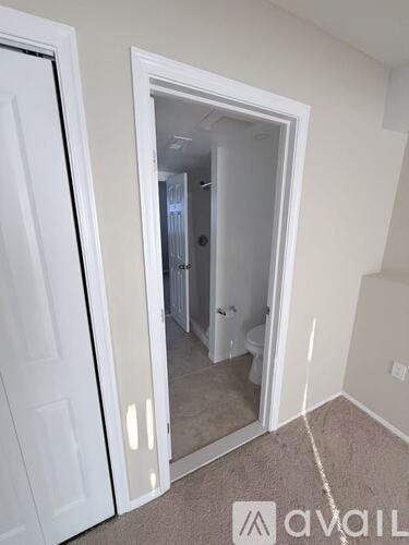 A white door is open to a bathroom.