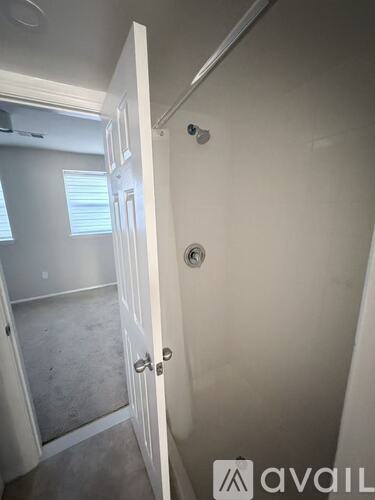 A white door with a silver handle is open.