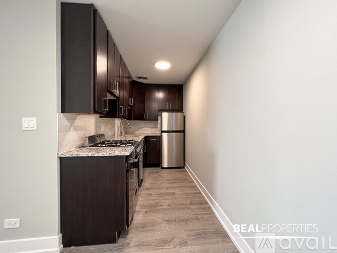 A kitchen with dark brown cabinets and a stainless steel refrigerator.