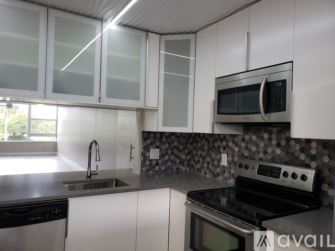 A kitchen with white cabinets and a black stove top oven.