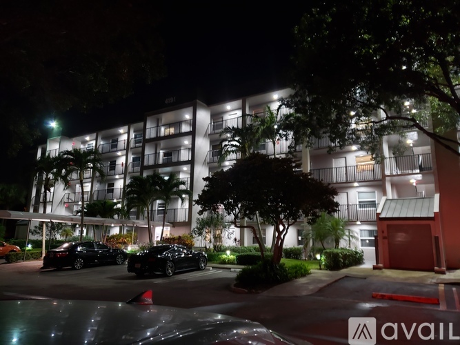 A building with a tree in front of it at night.