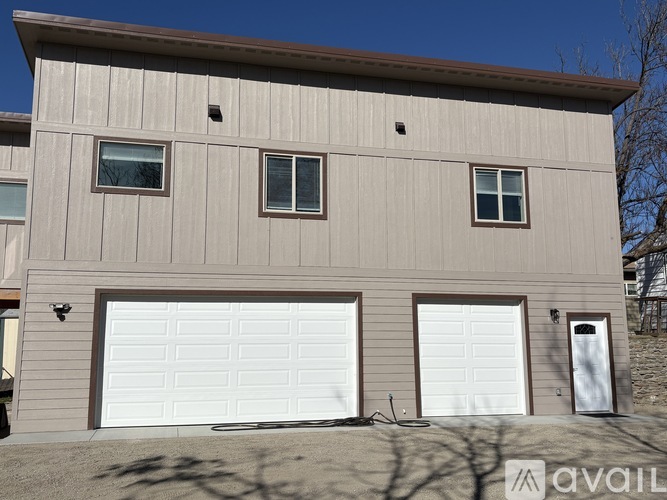A two-story house with a garage door and windows.