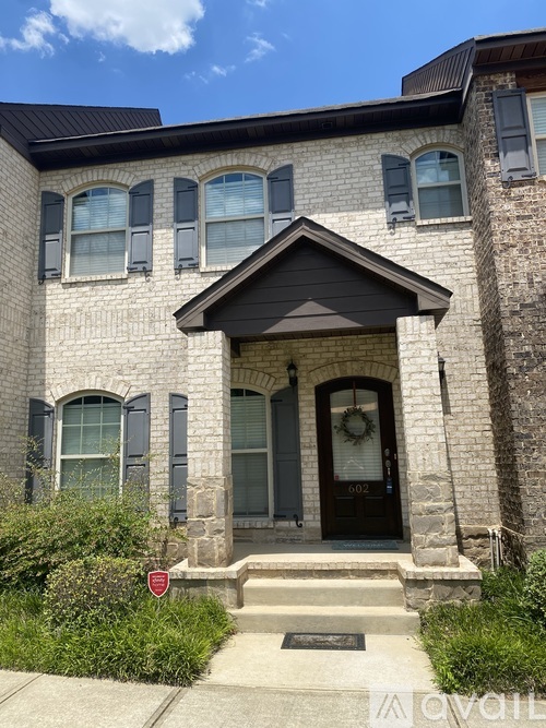 A house with a black door and a stop sign in front.
