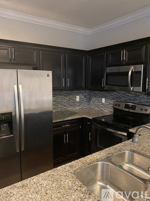 A kitchen with a granite countertop and stainless steel appliances.
