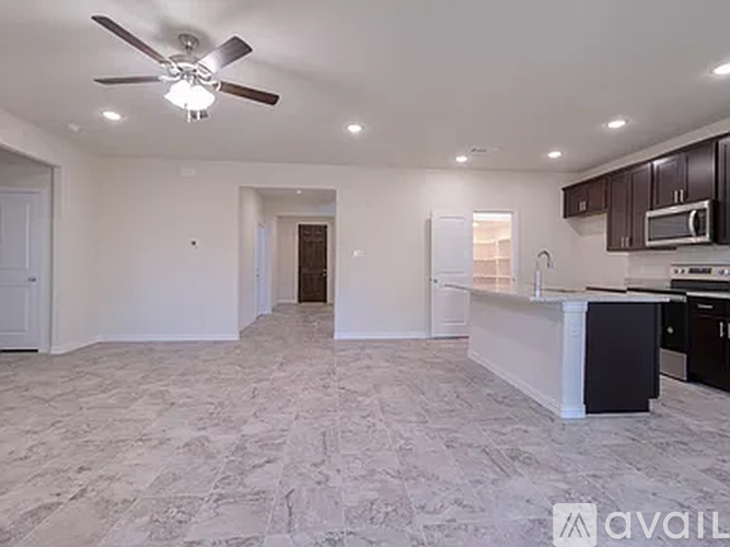 A spacious kitchen with a fan on the ceiling.